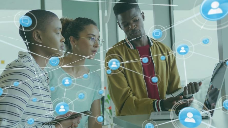 Three network operations engineers collaborating around a laptop with a digital overlay of a connected network node mesh, symbolizing unified telemetry and end-to-end network observability.